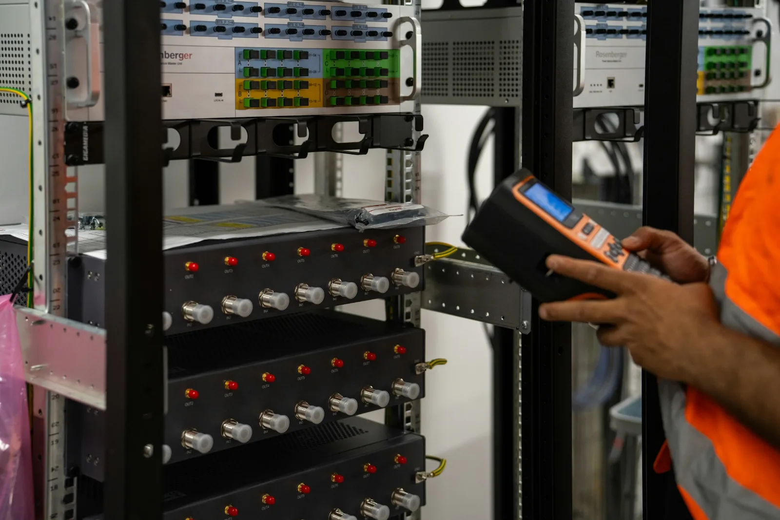 Rack kabinde ölçüm cihazıyla çalışan teknisyen